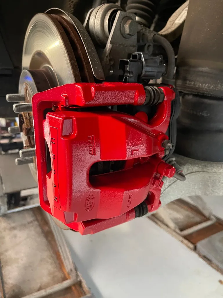 Gemonteerde Performance Red Gloss remklauw achter de velg van een Land Rover Defender L663